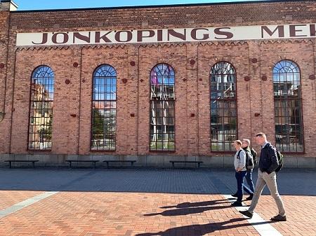Max, Johan och Ulf promenerar framför Jönköpings universitetsbibliotek.