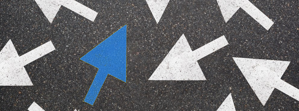 Flera pilar pekar åt olika håll. En av pilarna är blå.